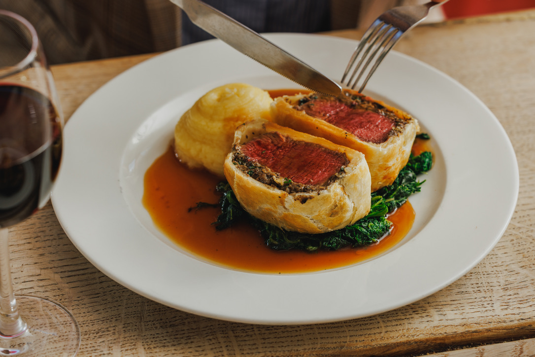 Beef Wellington wrapped in golden flaky pasty, with buttery mash and gravy.